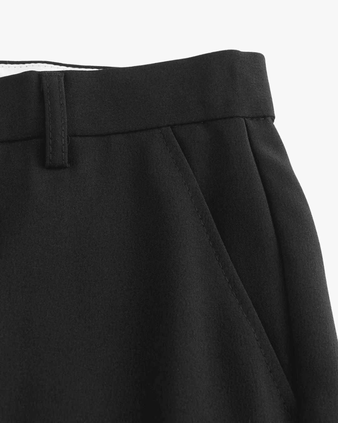 Close-up of black pants with a white background