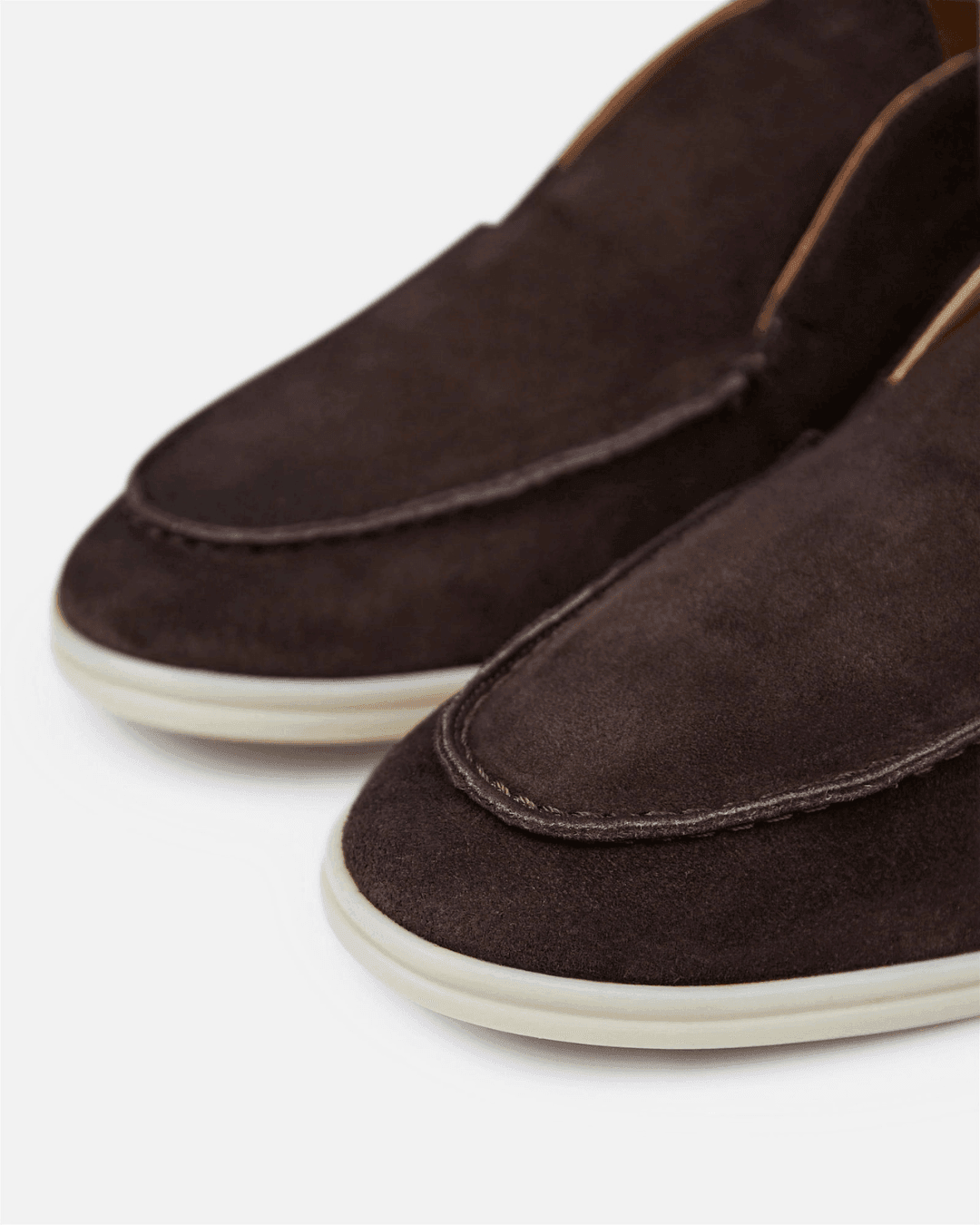 Brown suede loafers on a white background