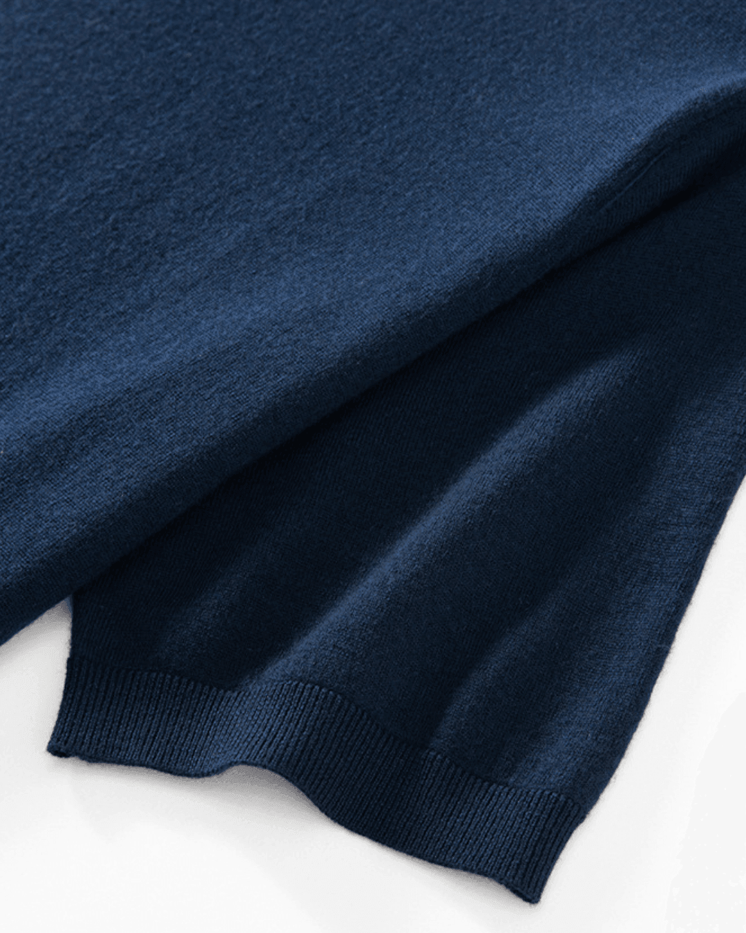 Close-up of a navy blue sweater on a white background